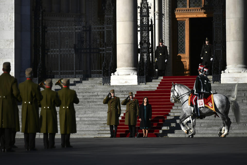 Katalin Novak, president of Hungary, center, attends the official flag raising ceremony for the 66th anniversary of Hungarian anti-communist uprising of 1956 in front of the Parliament in Budapest, Hungary, Sunday, Oct. 23, 2022. (AP Photo/Anna Szilagyi)