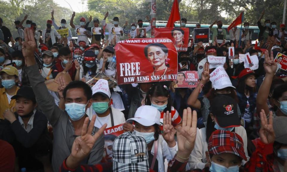 Protesters give a three-fingered salute of resistance during an anti-coup protest outside the Hledan Centre in Yangon.