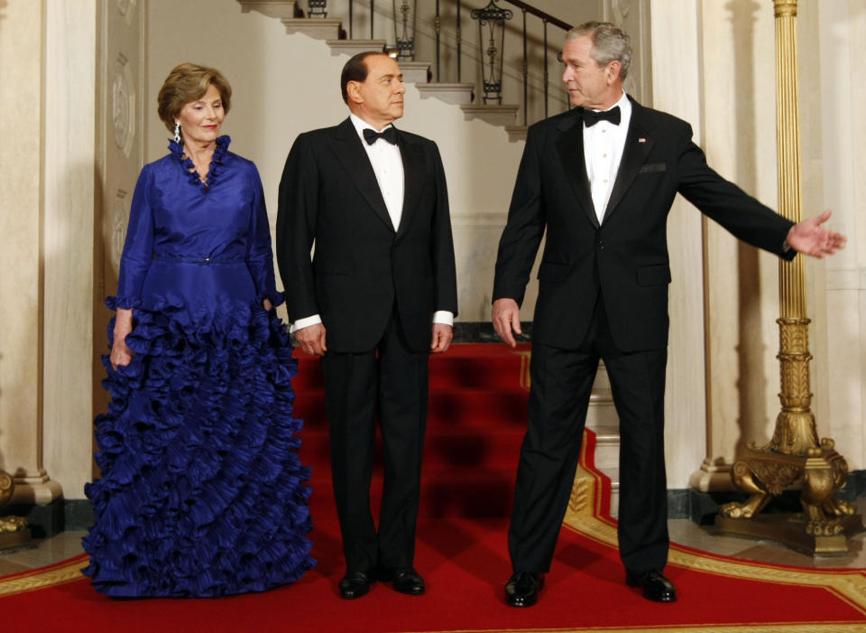 FILE - In this Oct. 13, 2008 file photo, U.S. President George Bush, right, gestures as he directs the Prime Minister of Italy Silvio Berlusconi, center, and the first lady Laura Bush, left, towards the East Room of White House, Monday, Oct. 13, 2008, in Washington. Berlusconi, the boastful billionaire media mogul who was Italy's longest-serving premier despite scandals over his sex-fueled parties and allegations of corruption, died, according to Italian media. He was 86. (AP Photo/Pablo Martinez Monsivais, File)