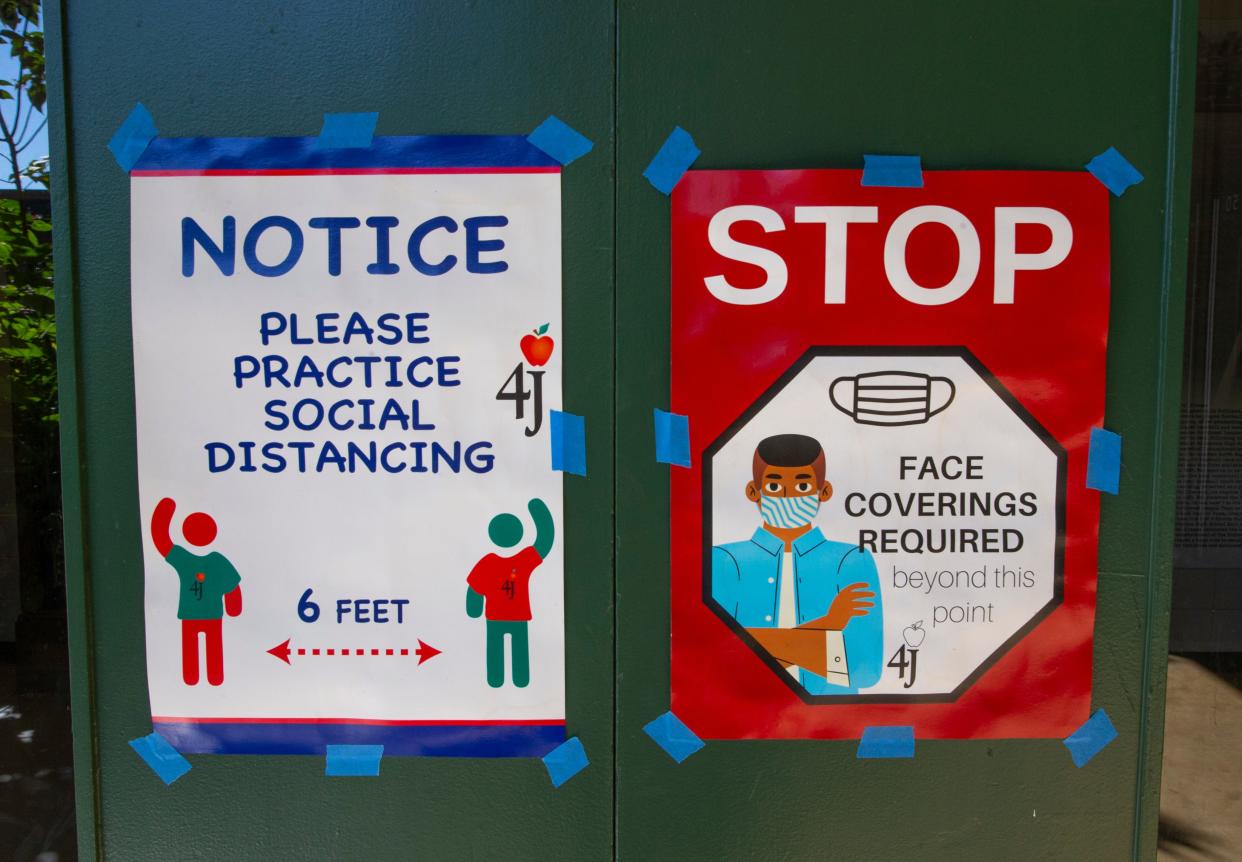Sign at the entry to Sheldon High School asks students to practice social distancing and to wear a mask.