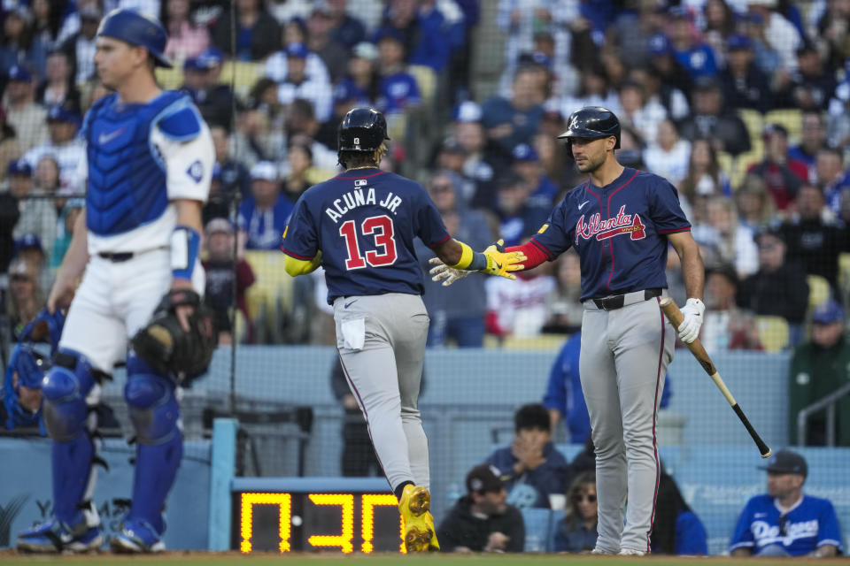 Atlanta Braves' Ronald Acuña Jr. (13) is greeted by Matt Olson, right, after scoring off of a single hit by Austin Riley during the fourth inning of a baseball game against the Los Angeles Dodgers in Los Angeles, Saturday, May 4, 2024. (AP Photo/Ashley Landis)