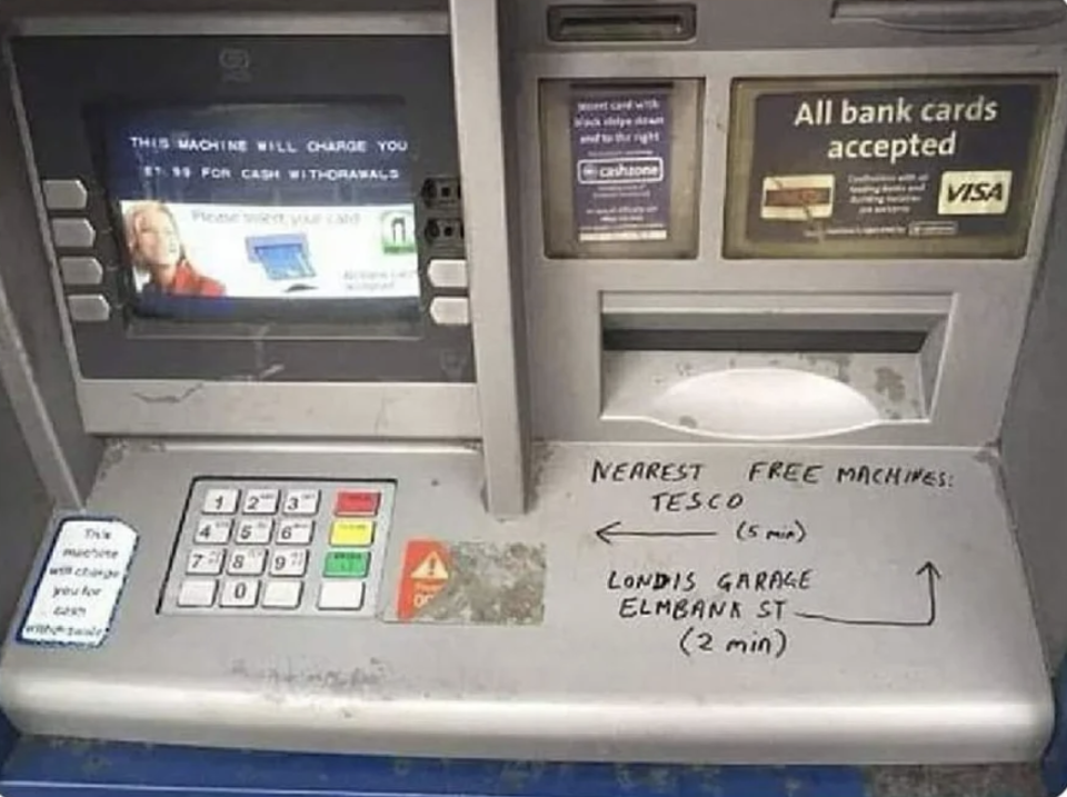 Graffiti on an ATM points people toward the closest ATM that doesn't charge an additional fee