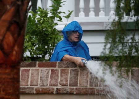 A resident pumps water from the yard of his home during Hurricane Dorian in Charleston