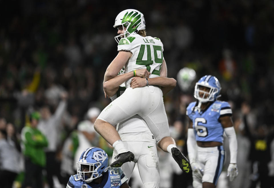 Oregon place-kicker Camden Lewis (49) is lifted by Adam Barry (93) after Lewis kicked an extra point against North Carolina during the second half of the Holiday Bowl NCAA college football game Wednesday, Dec. 28, 2022, in San Diego. (AP Photo/Denis Poroy)