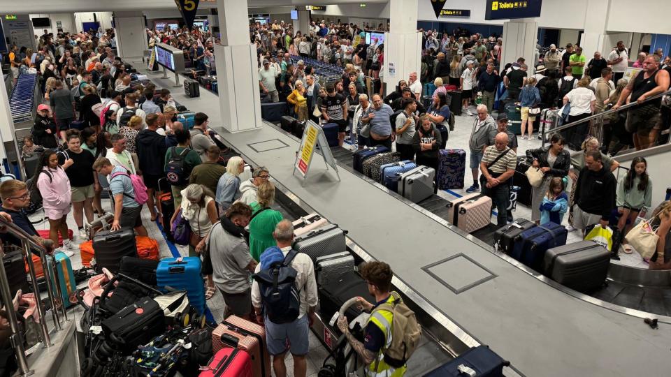 Passengers waiting to collect their luggage in Manchester Airport