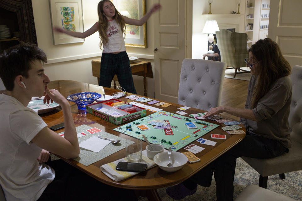 POUND RIDGE, NEW YORK - MARCH 22: A family, unable to venture beyond their home  because of the COVID-19 pandemic, play a game of monopoly together on March 22, 2020 in Pound Ridge, New York. (Photo by Andrew Lichtenstein/Corbis via Getty Images)