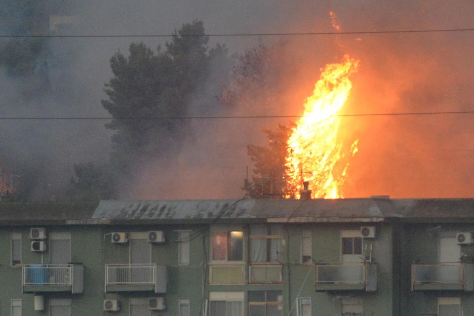 This photo obtained from Italian news agency Ansa shows a vast fire spreading on hills in the area of Monte Grifone and the town of Ciaculli around Palermo, Sicily, on July 25, 2023, with flames threatening nearby houses. Sicilian firefighters were fighting overnight against several fires, one of which neared Palermo airport, forcing it to close for several hours in the morning. (Photo by STRINGER / ANSA / AFP) / Italy OUT (Photo by STRINGER/ANSA/AFP via Getty Images)