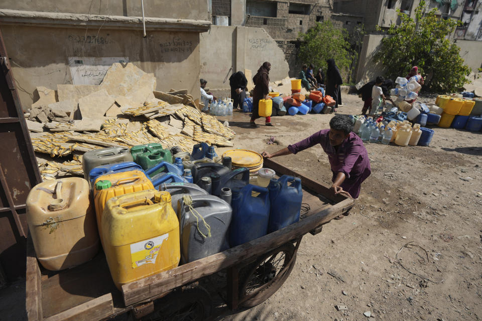 People get drinking water from a water collecting point at a slum area, in Karachi, Pakistan, Tuesday, March 21, 2023. World Water Day will be observed on March 22 to aim to highlight the importance of freshwater and advocate for sustainable management of this vital resource. (AP Photo/Fareed Khan)