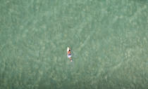 A surfer swims at Barra da Tijuca beach in Rio de Janeiro February 22, 2013. REUTERS/Ricardo Moraes (BRAZIL - Tags: TRAVEL SOCIETY SPORT TPX IMAGES OF THE DAY) - RTR3E4RH