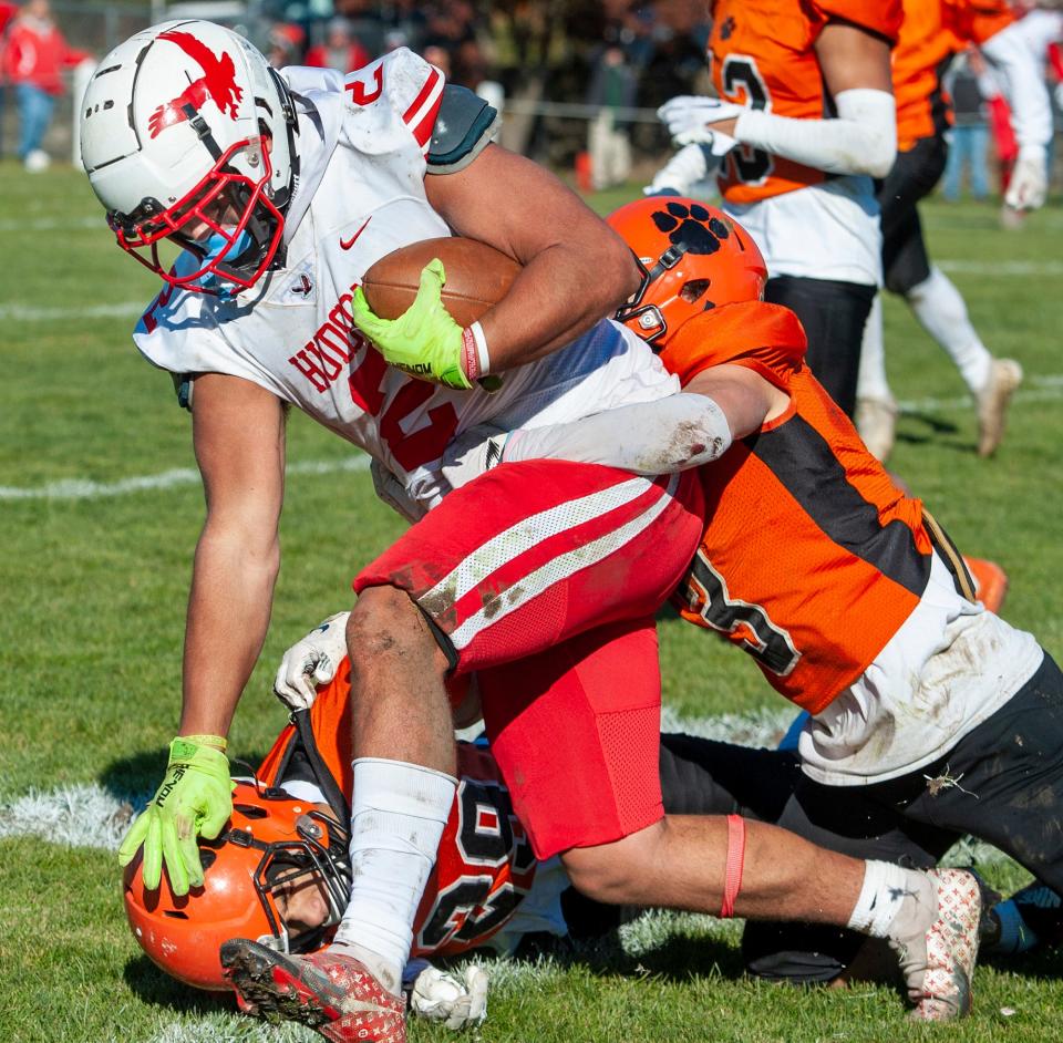 Hudson High School senior Caleb Ruz runs through tackles  at Marlborough's Kelleher Field, Nov. 24, 2022.