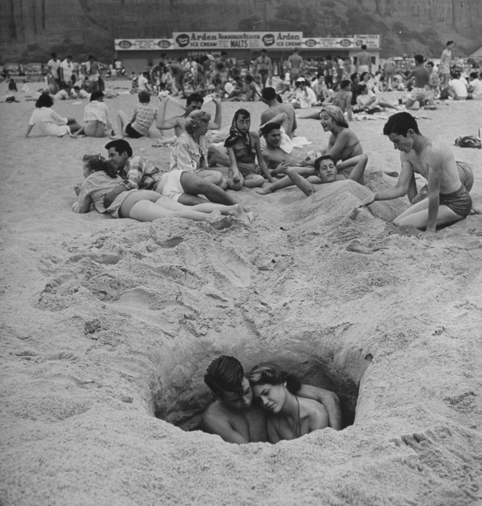 <p>A young couple cuddles on a hot Independence Day at the beach, Santa Monica, Calif., 1950. (Photo: Ralph Crane/The LIFE Images Collection/Getty Images) </p>