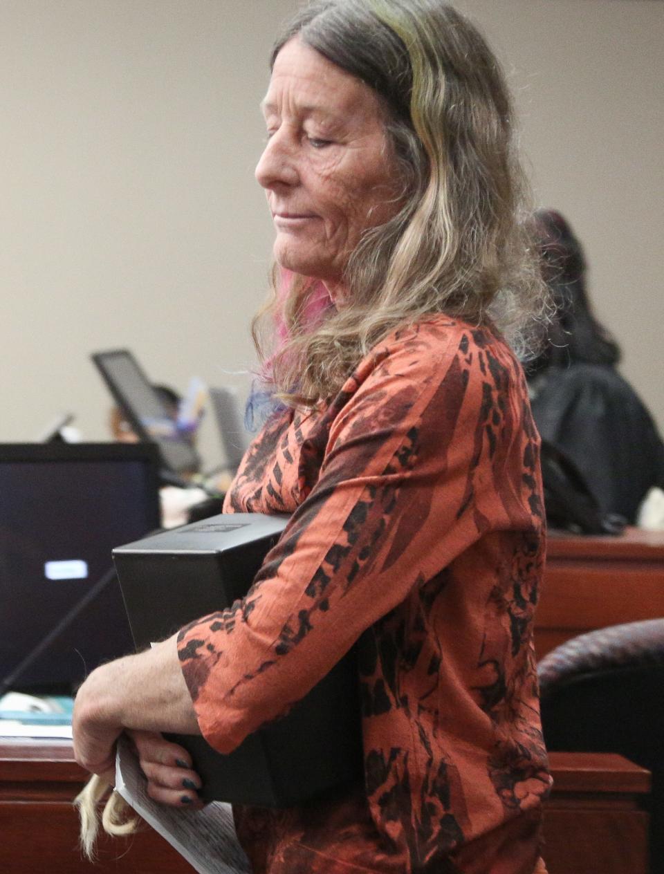 Holding her daughter's ashes and a lock of her hair, Denise Ward leaves the witness stand after giving her victim impact statement during Kiernan Brown's sentencing hearing in Judge Rosemarie Aquilina's courtroom, Wednesday, Nov. 2, 2022, for the brutal murders of two Lansing-area women in 2019, including her daughter Julie Mooney, 32, of Williamston, and Kaylee Brock, 26, of Holt.  "We will never forget what you did - how can we? You murdered our daughters around Mother's Day," she said. "May you smell death, but only from yourself. May you feel the pain of what you have done and will be done to you."