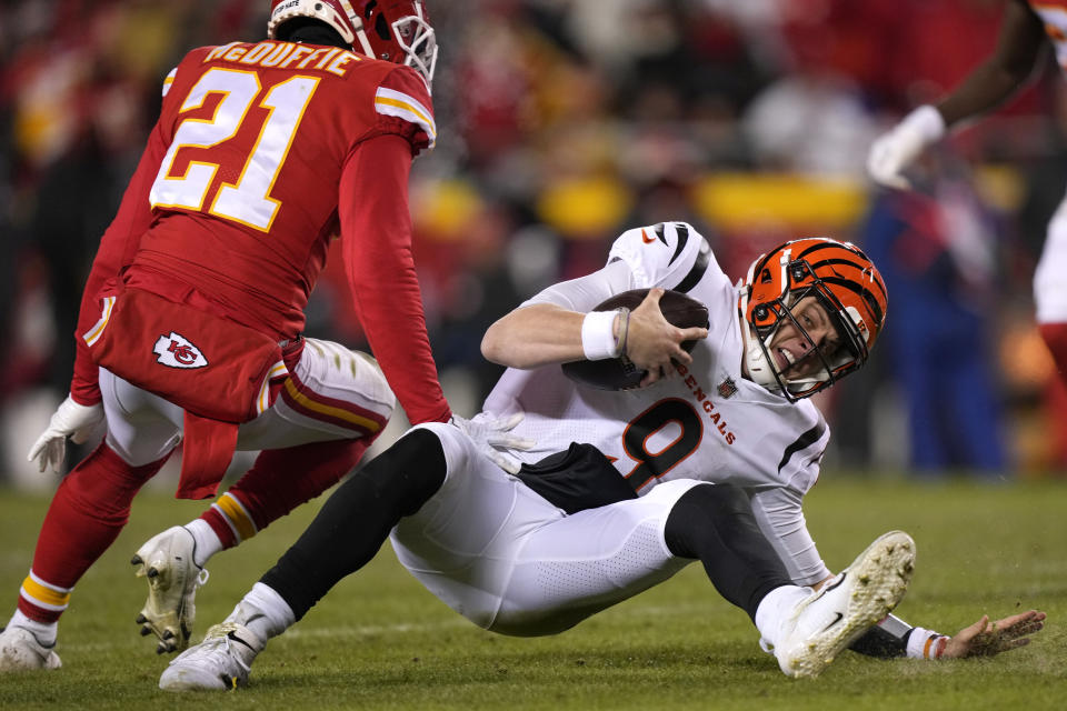 Kansas City Chiefs cornerback Trent McDuffie (21) tackles Cincinnati Bengals quarterback Joe Burrow (9) during the second half of the NFL AFC Championship playoff football game, Sunday, Jan. 29, 2023, in Kansas City, Mo. (AP Photo/Charlie Riedel)