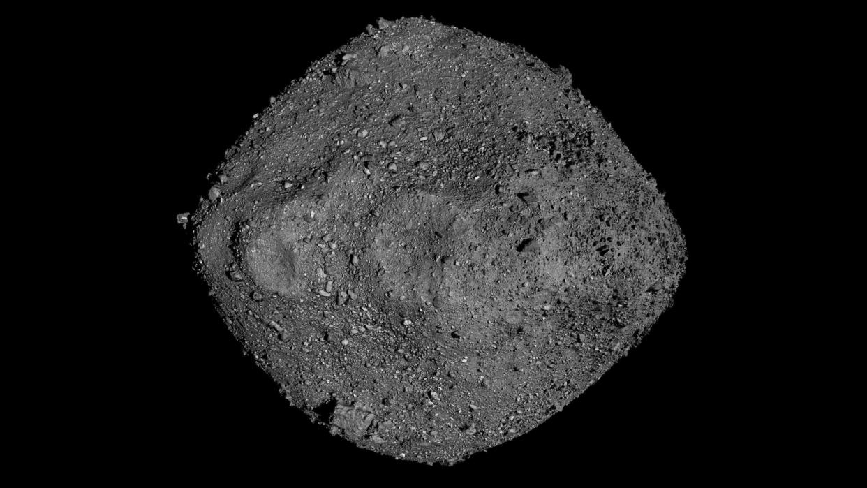  A ball of grey boulders and rocks seen against the blackness of space. 