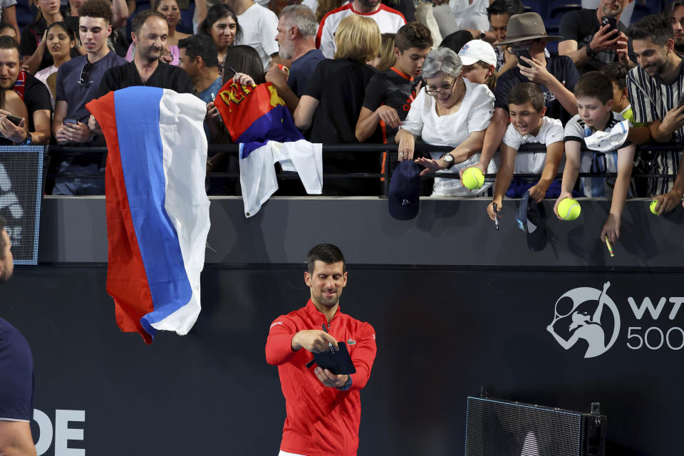 Serbia's Novak Djokovic poses for selfie with fans after defeating Russia's Daniil Medvedev during their semi final match at the Adelaide International Tennis tournament in Adelaide, Australia, Saturday, Jan. 7, 2023. (AP Photo/Kelly Barnes)
