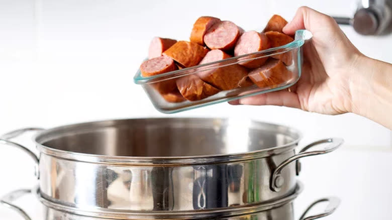 Putting smoked sausage pieces in stockpot