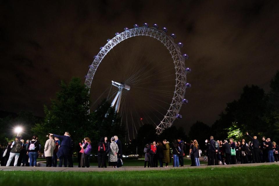 Members of the public stand in the queue on the South Bank in London adjacent to the London Eye, as they wait to view Queen Elizabeth II lying in state ahead of her funeral (PA)