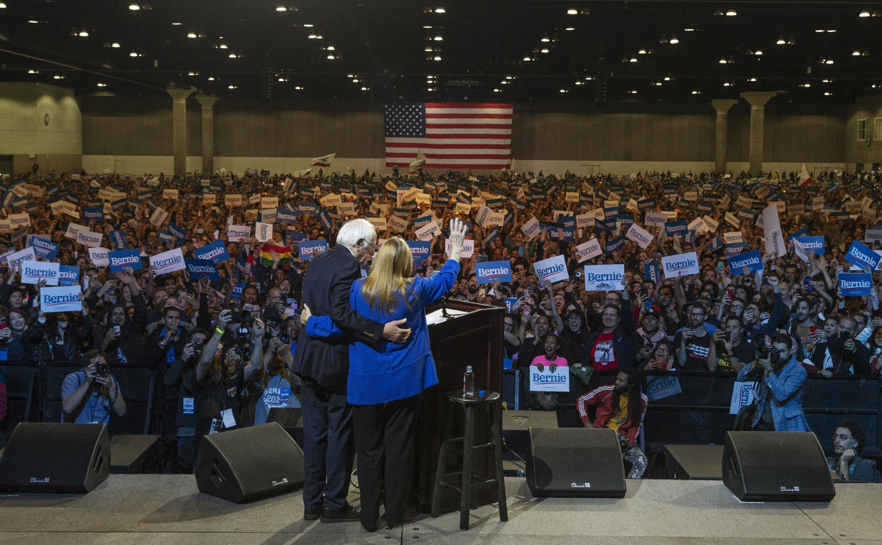 Jane Sanders and Sen. Bernie Sanders (I-Vt.) wave at supporters in Los Angeles on March 1, 2020. A sweeping victory in California would give Sanders a massive advantage that will be hard for his rivals to catch up to.