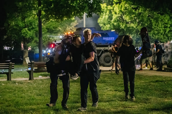 Demonstrators carry a wounded person, during a clash with law enforcement in Kenosha, Wisconsin. 