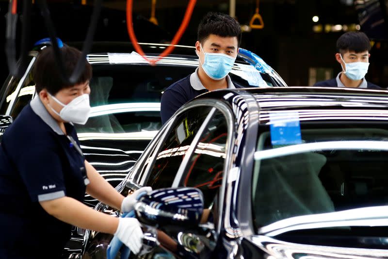 FILE PHOTO: Employees wearing face masks work at a plant of Daimler-BAIC joint venture’s Beijing Benz Automotive Co during a government organised tour of the facility following the outbreak of the coronavirus disease (COVID-19), in Beijing