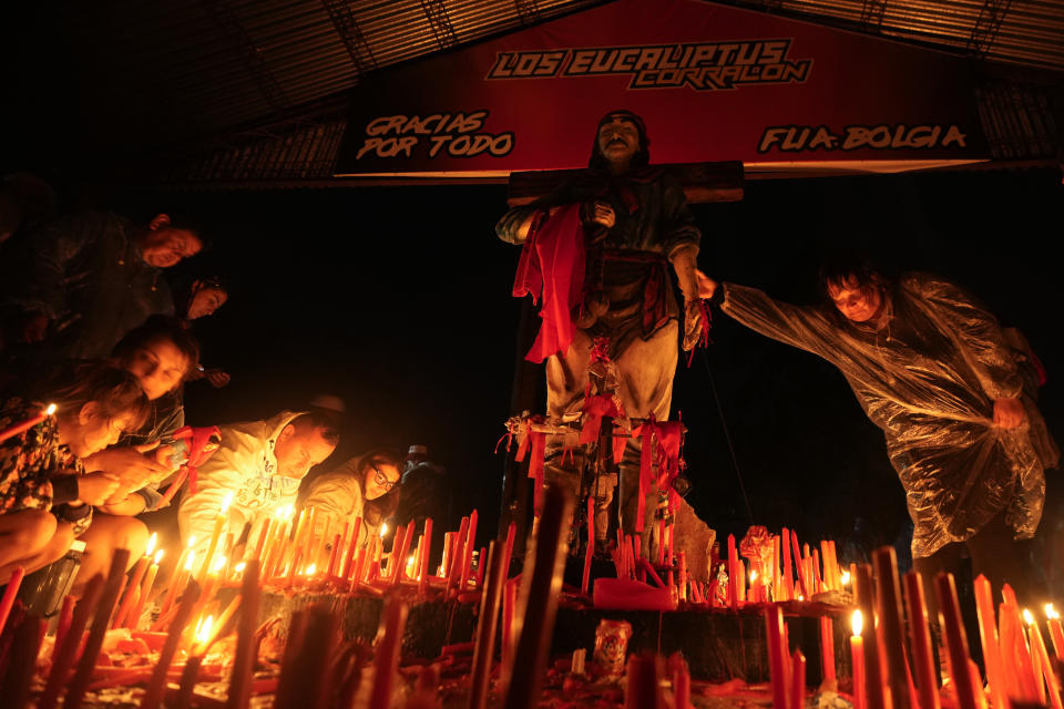 Una mujer toca una representación del santo pagano argentino Gauchito Gil en su santuario en Mercedes, Corrientes, Argentina, el domingo 7 de enero de 2024. Cada 8 de enero, devotos de todo el país visitan ese espacio para pedir o agradecerle por milagros. (AP Foto/Natacha Pisarenko)