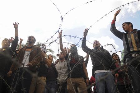 Students of Cairo University, who are supporters of the Muslim Brotherhood and ousted Egyptian President Mohamed Mursi, shout slogans against the military and interior ministry during a demonstration in front of at the main gate of the university in Cairo December 9, 2013. REUTERS/Stringer