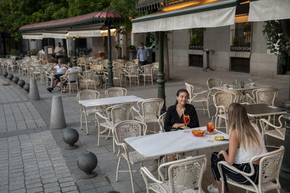 Women sit at the terrace of a restaurant at Opera Square in Madrid