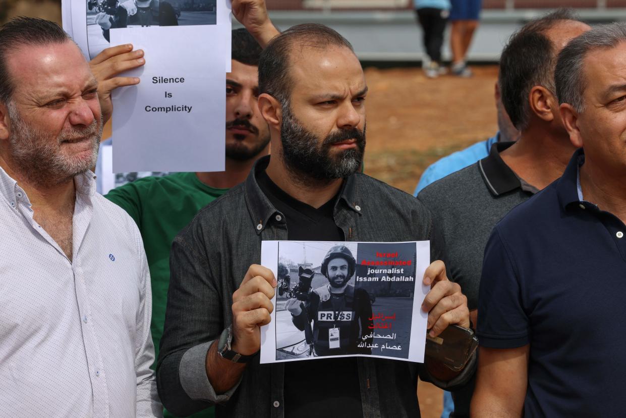 People lift placards and portraits of video journalist Issam Abdallah, killed on Oct. 13 by Israeli shelling at Alma al-Shaab border village with Israel while covering cross border shelling, during a protest facing U.N. headquarters in downtown Beirut on Oct. 15.