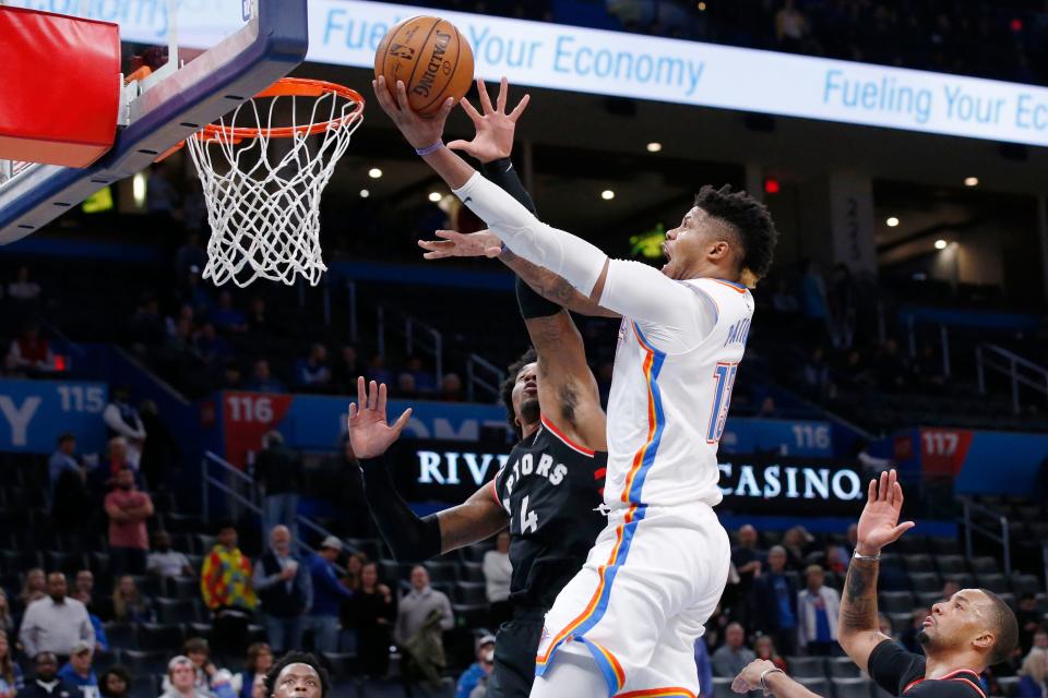 Oklahoma City Thunder center Justin Patton, center, goes to the basket in front of Toronto Raptors forward Rondae Hollis-Jefferson (4) during the second half of an NBA basketball game Wednesday, Jan. 15, 2020, in Oklahoma City. (AP Photo/Sue Ogrocki)