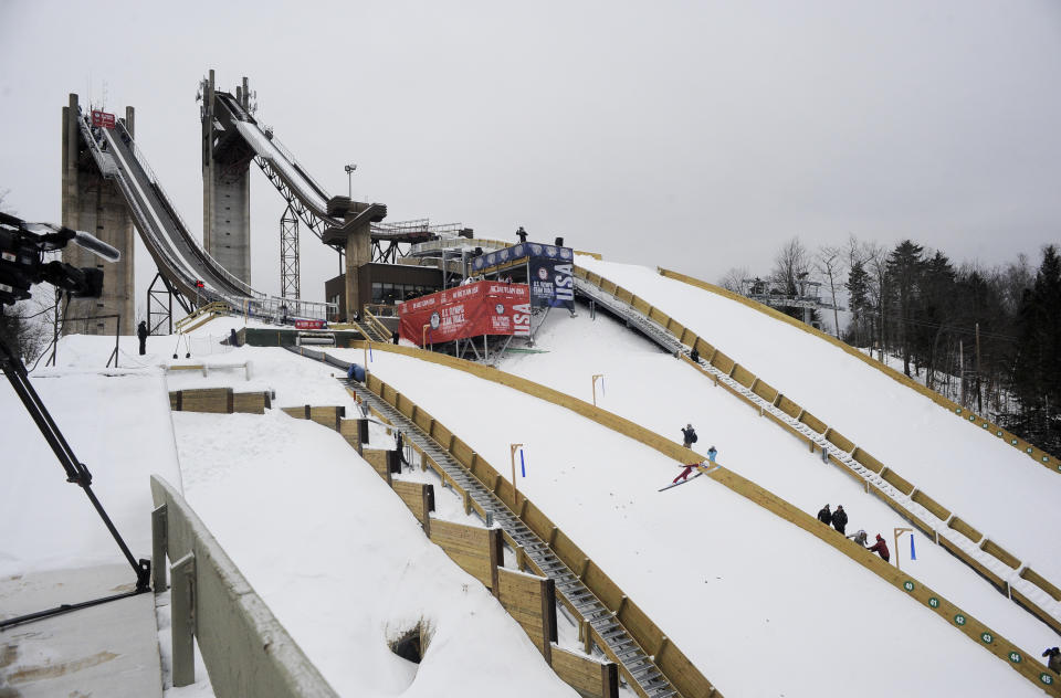 FILE - Jumpers soar through the air during the ski jumping competition for placement on the 2022 U.S. Olympic team at the Olympic Ski Jumping Complex Friday, Dec. 24, 2021, in Lake Placid, N.Y. The International Ski and Snowboard Federation is hosting a World Cup ski jumping competition Saturday and Sunday in Lake Placid, bringing the best in the sport back to town for the first time since 1990 and to the United States for the first time in nearly two decades. (AP Photo/Hans Pennink, File)