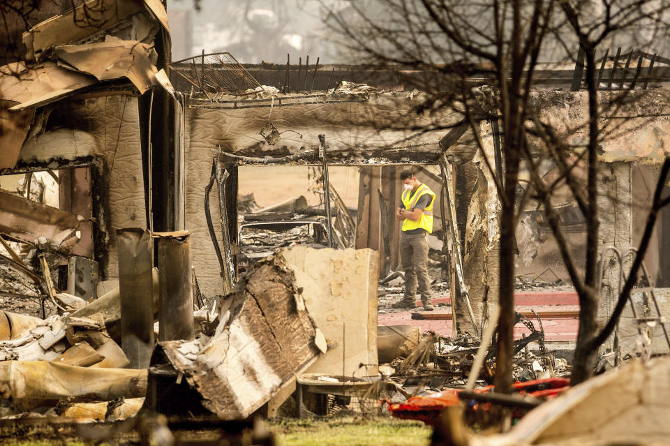 Utility worker Jake Orton examines a building destroyed by the Almeda Fire at the Parkview Townhomes in Talent, Ore., on Wednesday, Sept. 16, 2020. (AP Photo/Noah Berger)