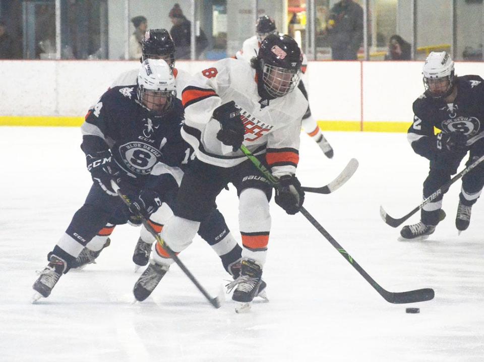 Sault Ste. Marie's Garrett Gorsuch (14) looks to take possession of the puck from Cheboygan's Carson Bigger (8) during the first period at Ralph G. Cantile Arena in Cheboygan on Wednesday.