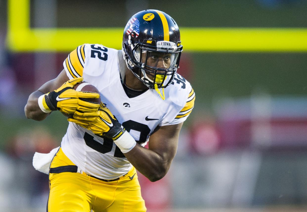 Iowa running back Derrick Mitchell Jr. (32) rushes the ball into the Indiana defense during the second half of an NCAA college football game in Bloomington, Ind., Saturday, Nov. 7, 2015. Iowa won 35-27. (AP Photo/Doug McSchooler)