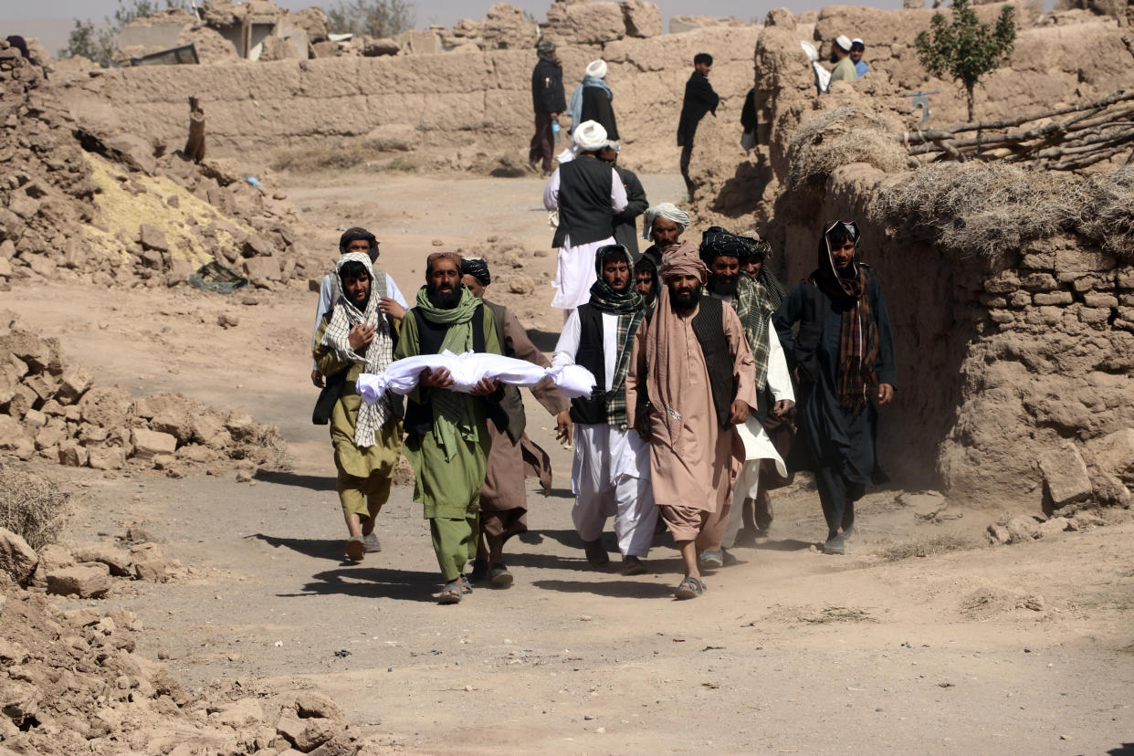 People carry the covered body of a child.
