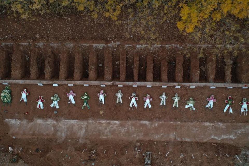 Varias coronas de flores permanecen colocadas junto a tumbas recién abiertas en una zona destinada a fallecidos por coronavirus de un cementerio de Salónica. (Foto: Alexandros Avramidis / Reuters).