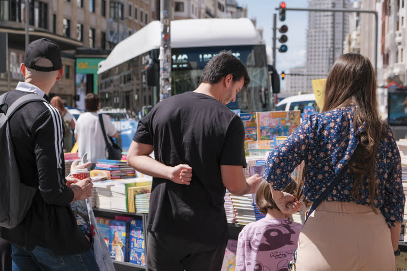 西班牙首都馬德里「格蘭大道」街頭書攤與讀者 西班牙首都馬德里在「世界閱讀日」前的週末假期， 於「格蘭大道」舉辦街頭書市，許多書攤在人行步道 上展售新書和二手書，也包括許多童書，引來大小讀 者圍聚在書攤前翻閱。 中央社記者胡家綺馬德里攝 113年4月22日 