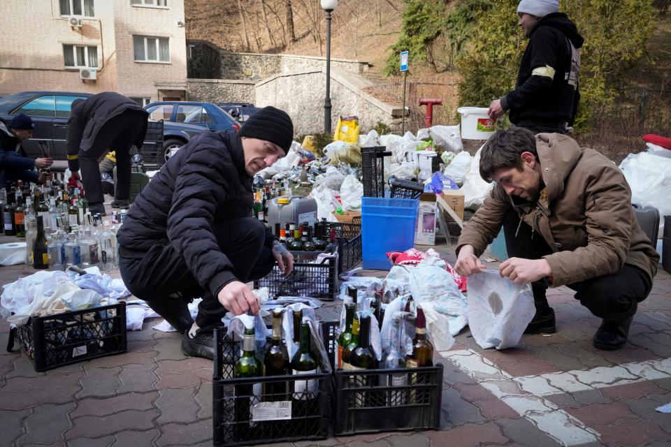 Members of civil defense prepare Molotov cocktails in a yard in Kyiv, Ukraine, Sunday, Feb. 27, 2022.