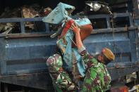 Soldiers load onto a truck an aircraft seat recovered from the Indonesian Air Force C-130 Hercules wreckage on July 1, 2015, a day after the plane crashed into a neighbourhood in Medan city