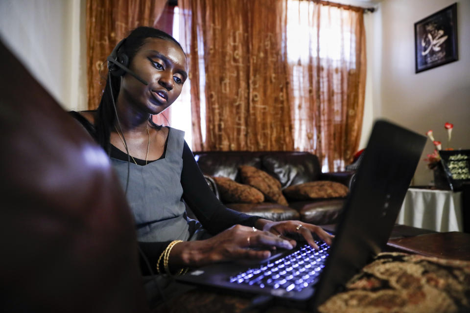 Maryama Diaw, a contact tracer with New York City's Health + Hospitals battling the coronavirus pandemic, sets up her remote calling system at her home before reaching out to potential patients Wednesday, Aug. 5, 2020, in New York. The city has hired more than 3,000 tracers and the city says it's now meeting its goal of reaching about 90% of all newly diagnosed people and completing interviews with 75%. (AP Photo/John Minchillo)