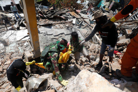 A victim of last week's earthquake is recovered in the Balaroa neighbourhood in Palu, Central Sulawesi, Indonesia October 6, 2018. REUTERS/Darren Whiteside