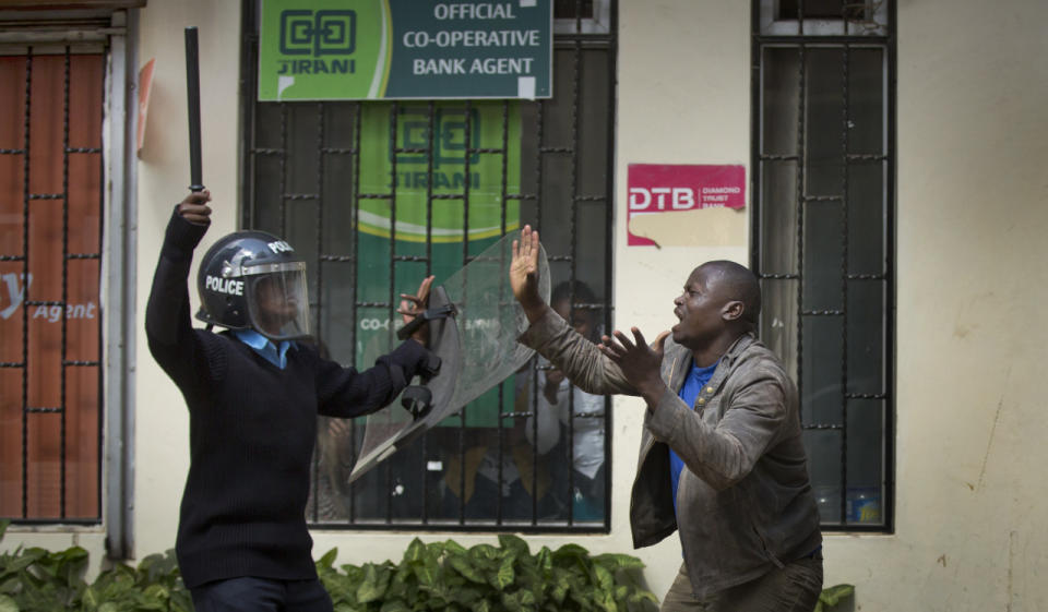 An opposition supporter pleads with a riot policeman after being beaten with a wooden club by one, managing to escape, but then being cornered by another, during a protest in downtown Nairobi, Kenya, May 16, 2016. Kenyan police have tear-gassed and beaten opposition supporters during a protest demanding the disbandment of the electoral authority over alleged bias and corruption. (AP Photo/Ben Curtis)
