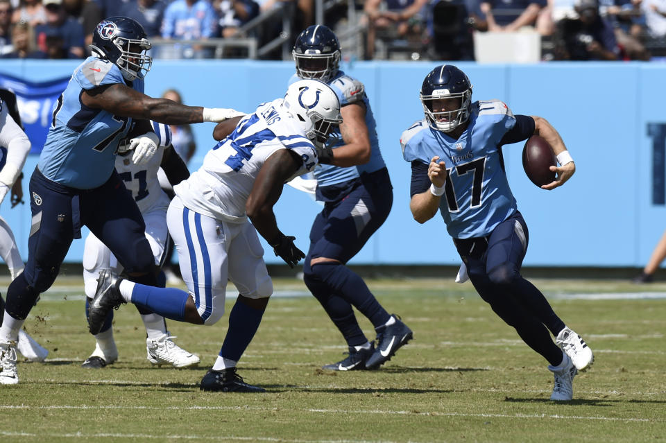Tennessee Titans quarterback Ryan Tannehill (17) scrambles past Indianapolis Colts defensive end Tyquan Lewis (94) in the first half of an NFL football game Sunday, Sept. 26, 2021, in Nashville, Tenn. (AP Photo/Mark Zaleski)