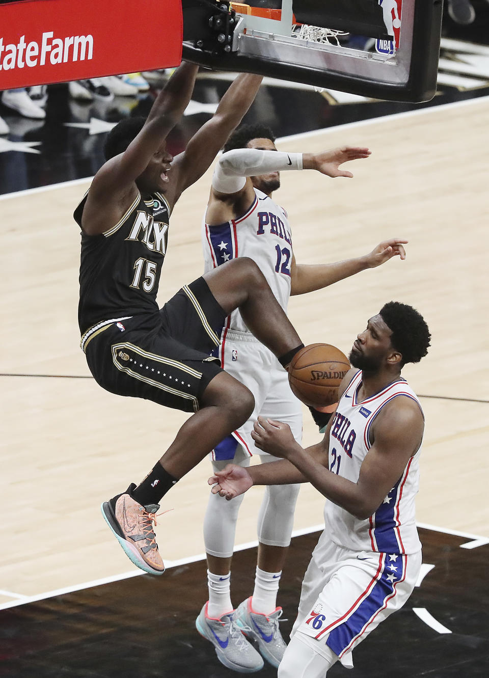 Atlanta Hawks center Clint Capela slams for two points over Philadelphia 76ers defenders Joel Embiid, right, and Tobias Harris on a lob pass from Hawks' Trae Young during the fourth quarter of Game 4 of a second-round NBA basketball playoff series on Monday, June 14, 2021, in Atlanta. (Curtis Compton/Atlanta Journal-Constitution via AP)