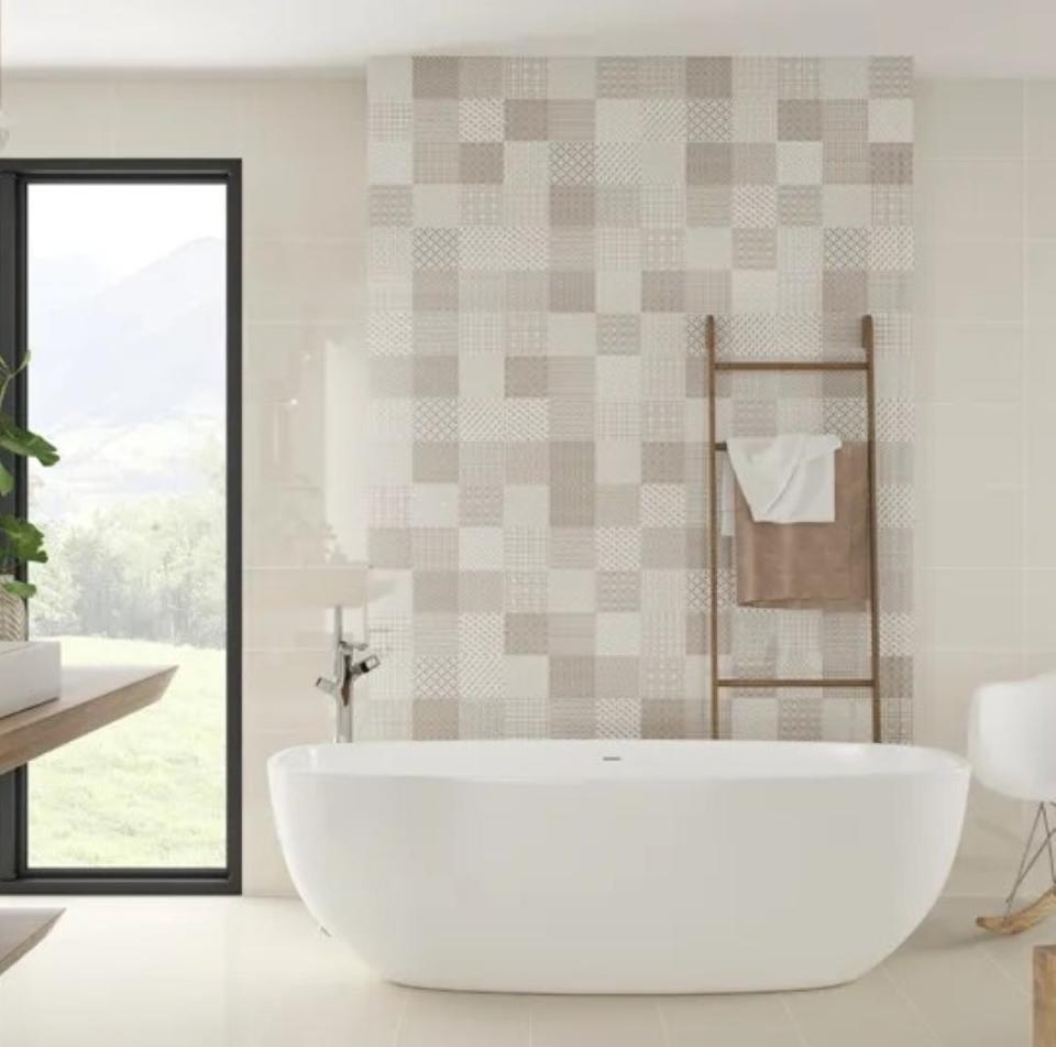 Neutral colored quilt tiles on a wall behind a bathtub