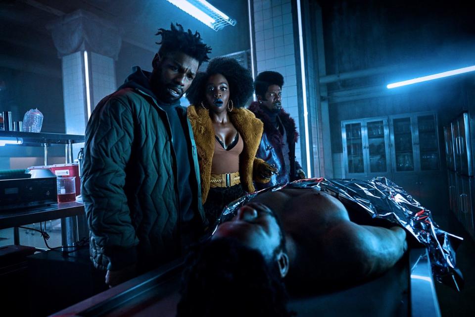 Da liegt er nun und kann nicht anders: Fontaine (John Boyega, links) entdeckt zusammen mit  Yo-Yo (Teyonah Parris) und Slick Charles (Jamie Foxx) die Leiche seines Klons. (Bild: Parrish Lewis/Netflix © 2023)