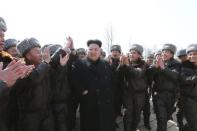 North Korean leader Kim Jong Un (C) visits Unit 447 of the Korean People's Army (KPA) Air and Anti-Air Force honoured with the title of O Jung Hup-led 7th Regiment and plant trees with fighter pilots of the unit in this undated photo released by North Korea's Korean Central News Agency (KCNA) in Pyongyang March 3, 2015. REUTERS/KCNA