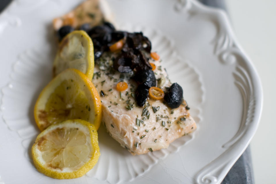 This Dec. 2, 2013 photo shows salmon that has been baked in a bag with citrus, olive and chilies in Concord, N.H. The bag keeps the flavor and moisture trapped inside during cooking, allowing the juices from the fish and the other ingredients to mingle and become a wonderful sauce. (AP Photo/Matthew Mead)