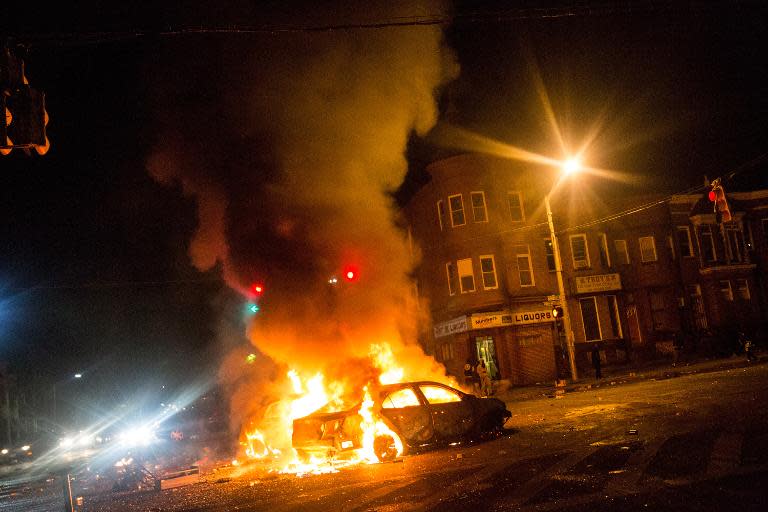 Cars burn in the middle of an intersection at New Shiloh Baptist Church on April 27, 2015 in Baltimore, Maryland