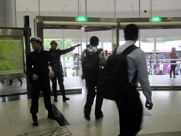 Members of the Land Transport Authority and the Home Team were also activated to assist in ensuring orderly dispersal of commuters to the bus bridging services at street level at Dhoby Ghaut station. (Yahoo! photo/Jeanette Tan)