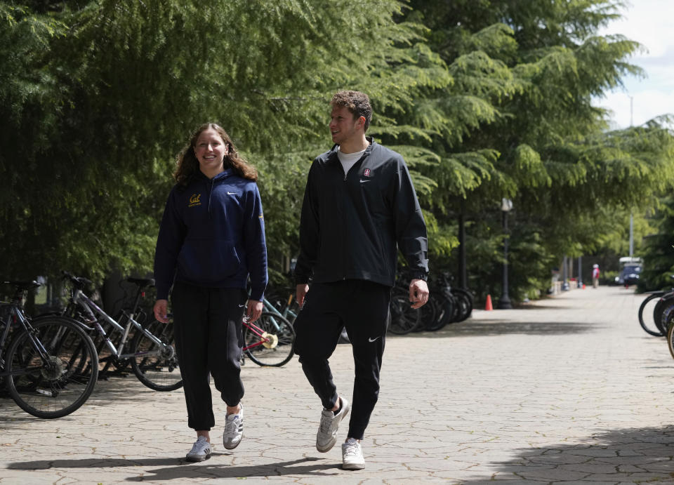 Siblings Leah, left, and Ron Polonsky walk through the Stanford University campus, Saturday, April 6, 2024, in Stanford, Calif. Ron swims for Stanford. Leah competes at rival California, in nearby Berkeley. (AP Photo/Godofredo A. Vásquez)